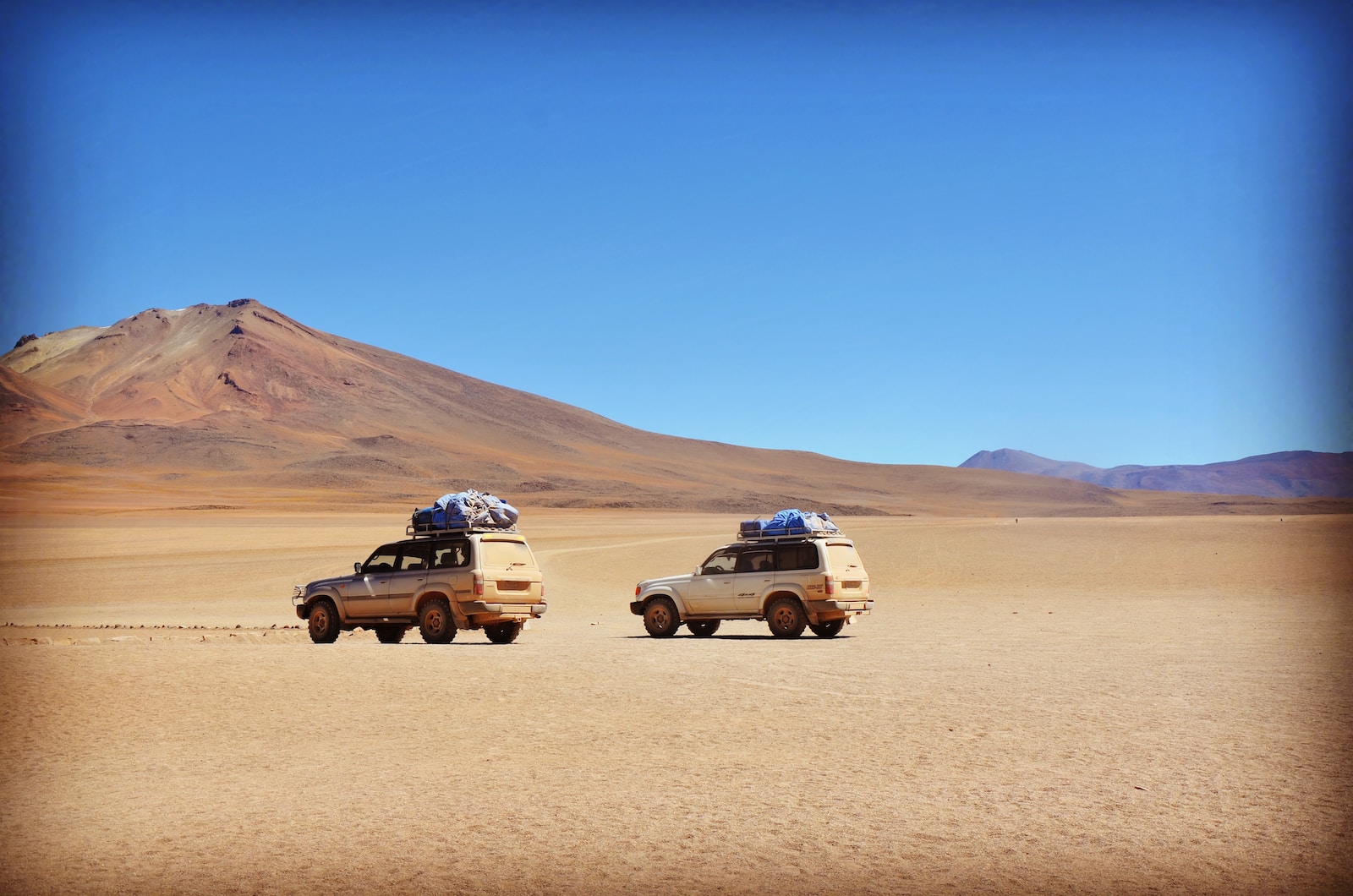 two grey SUV's on grey desert