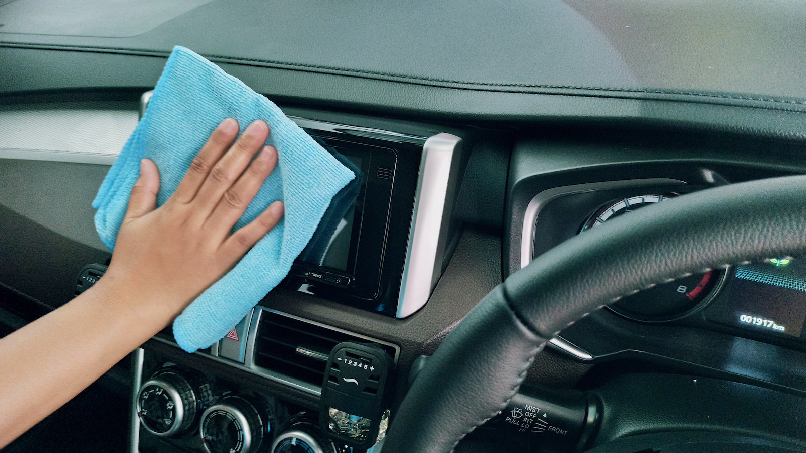 Crop person wiping modern car panel